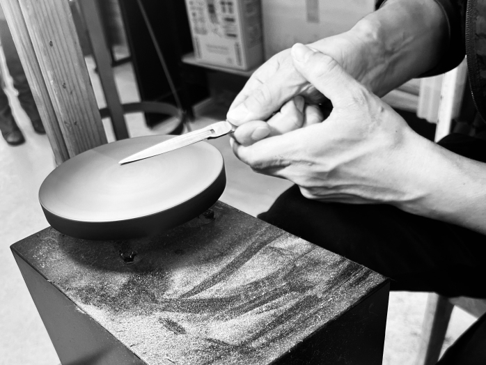 A Dune scissor blade being sharpened by hand